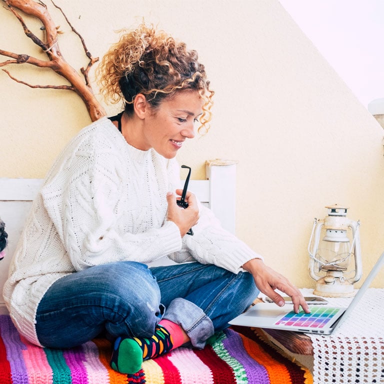 Woman-researching-payday-loan-atlternatives-in-OKC-and-found-fast-cash-loans-through-Allegiance-online-on-her-laptop-sitting-criss-cross.