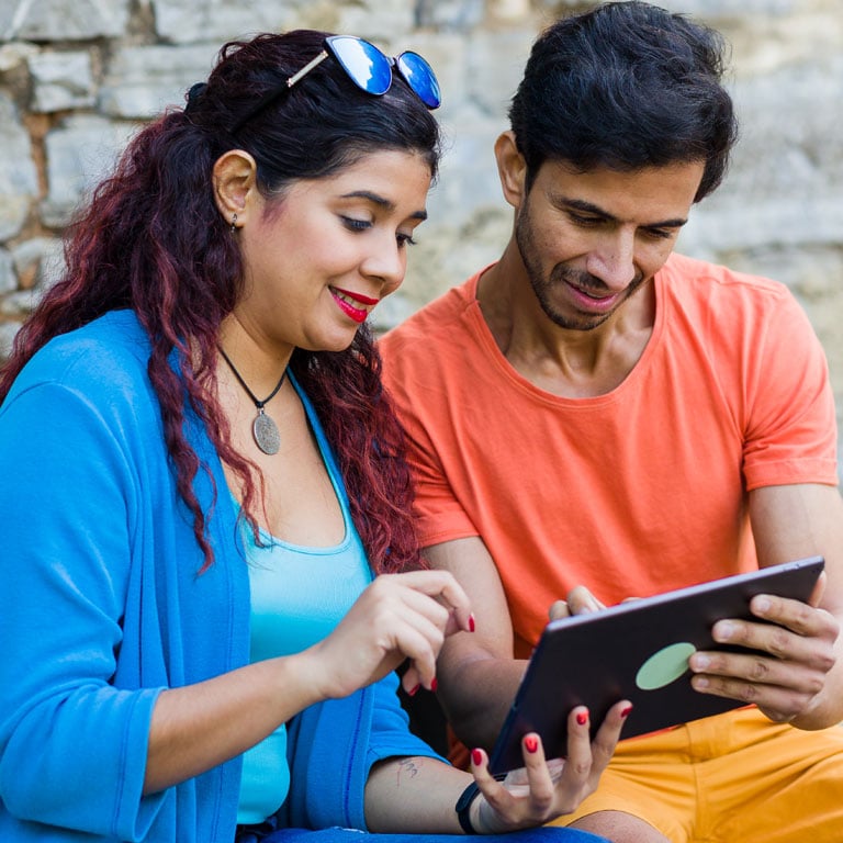 Couple-researching-peronal-line-of-credit-vs-personal-loan-differences-outside-on-a-tablet-together.