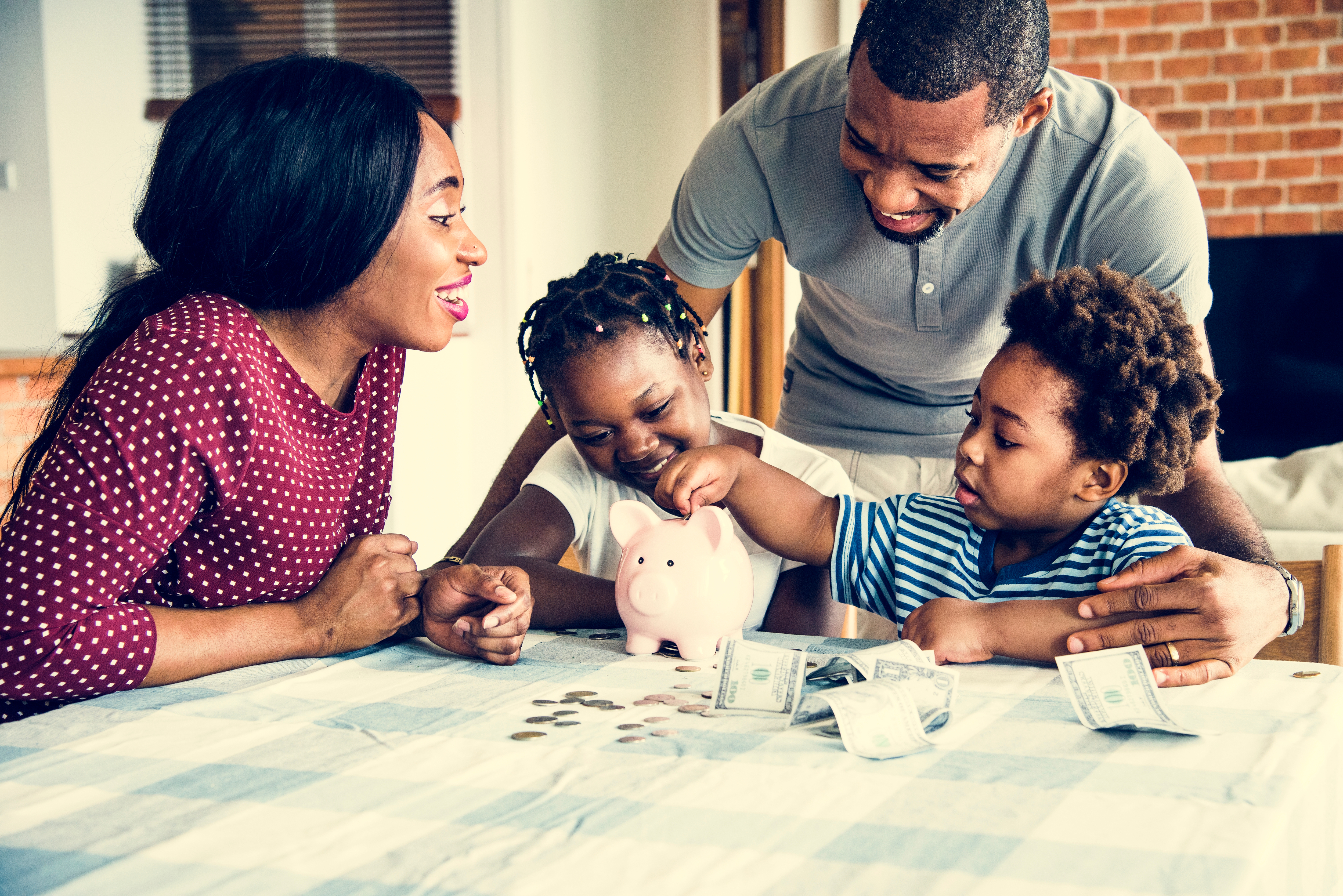 Parents counting piggy bank change with daughter and son